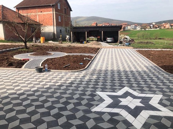 "Kilit Taşı Fiyatları" yazan, kilitli parke taşı bir yolda.