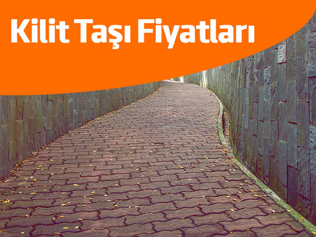 Kilitli parke taşlarıyla döşenmiş, ağaçlarla çevrili bir yürüyüş yolu.