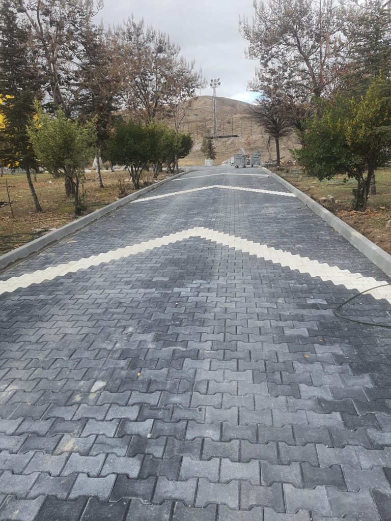 Siyah ve beyaz kilitli parke taşlarıyla döşenmiş modern bir yürüyüş yolu.