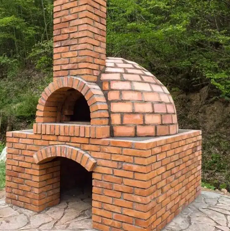 Bahçeye özel inşa edilmiş, kubbeli kırmızı tuğla yapılı geleneksel taş fırın modeli.